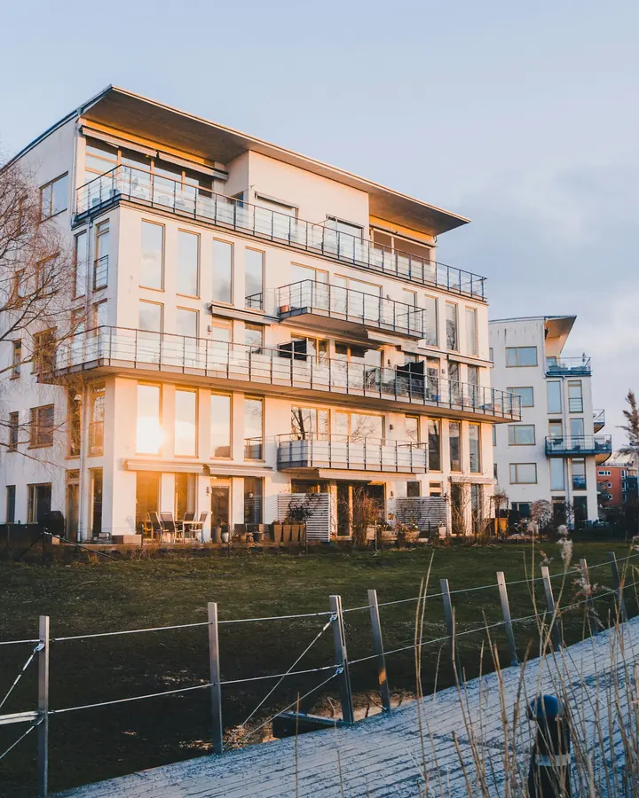 Modernt flerbostadshus med balkonger i kvällssol